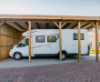 Hochcarport aus Leimholz mit Wohnmobil. Leimholz bzw. Brettschichtholz kommt häufig bei Holzbauten mit statischer Beanspruchung zum Einsatz.
